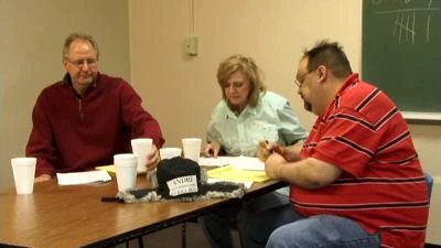 Preoccupied jurors Caffin (Scott Gilbraith), Sally (Nancy Monroe), and Andre (Brad Reissig) argue about the evidence they are examining.