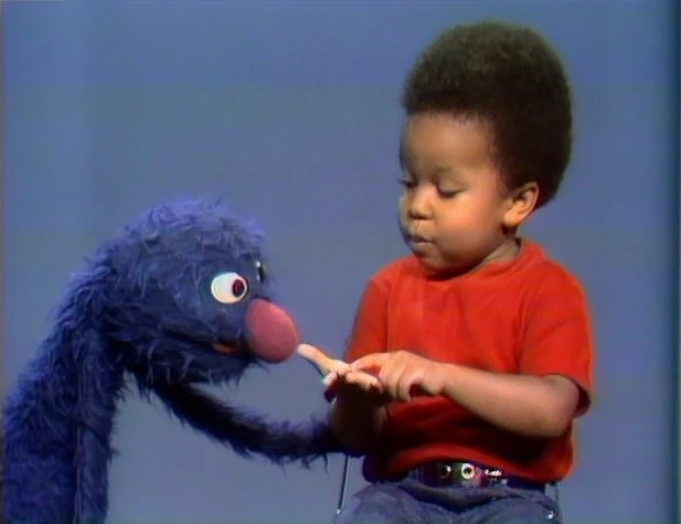Grover and John-John count a penny.