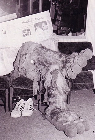 Richard Hunt, head obscured, lounging as Sweetums.