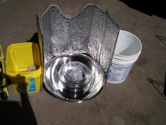 Inside this cooker is a Pyrex Pie Plate on a short candle stand. On top is a Pyrex Bowl. More info: http://arnies-solarcooking.blogspot.com/2008/06/steel-bowl-cooker_22.html